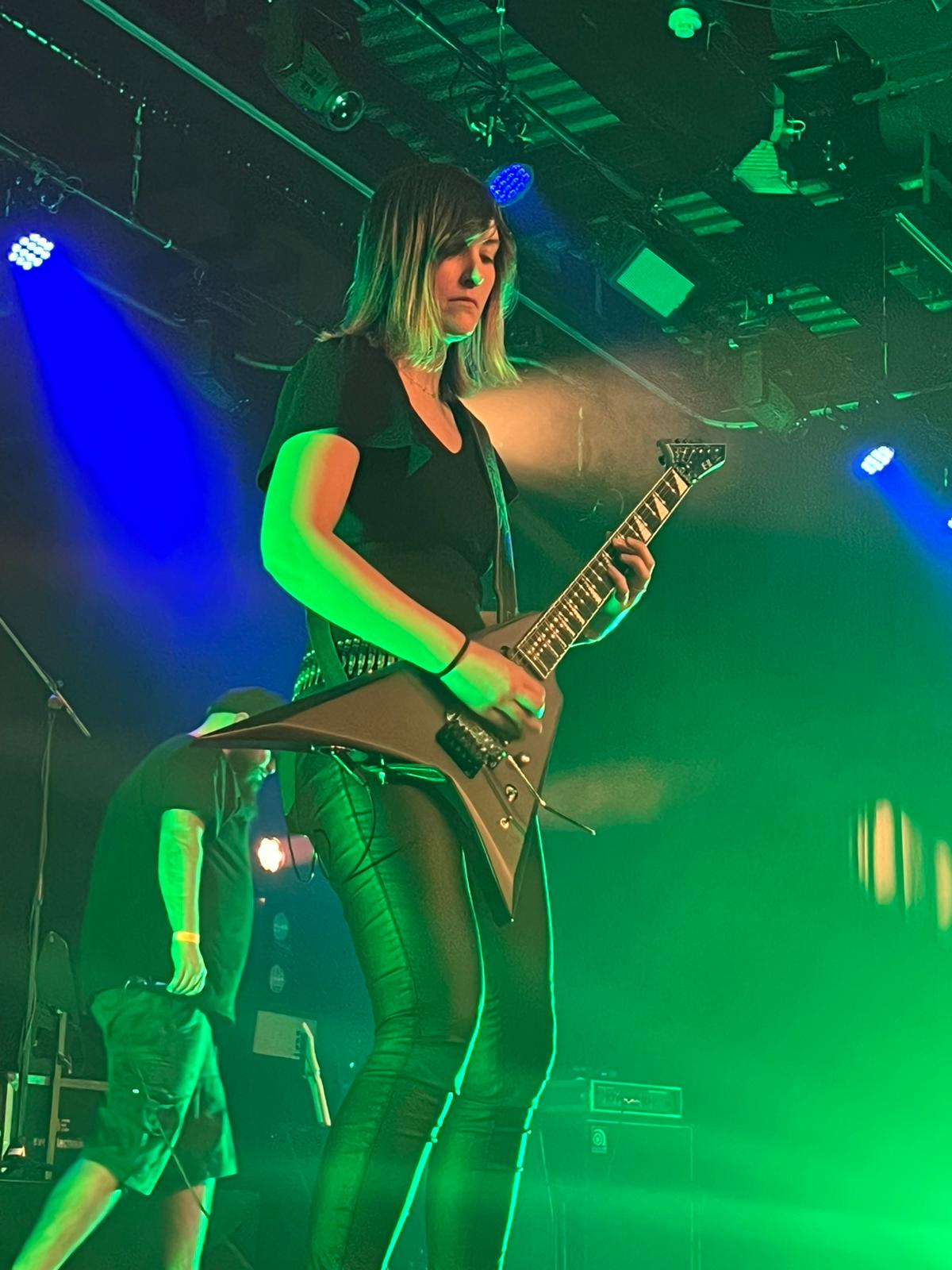 Jessi playing rhythm guitar live with From Grace